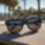 A close-up of black Wayfarer sunglasses resting on a skateboard.