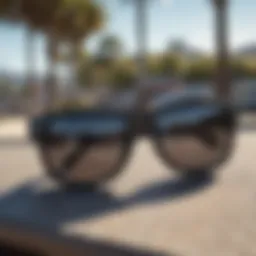 A close-up of black Wayfarer sunglasses resting on a skateboard.