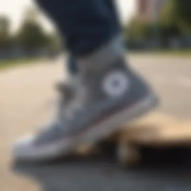 Low top gray Converse sneakers on a skateboard