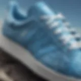 Close-up view of sky blue Adidas sneakers with intricate design.